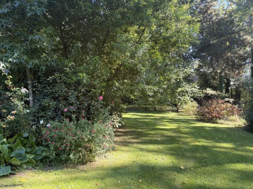 Jardin luxuriant avec arbustes en fleurs et pelouse verdoyante à la villa Mon Week End A La Mer à Varengeville-sur-Mer, France