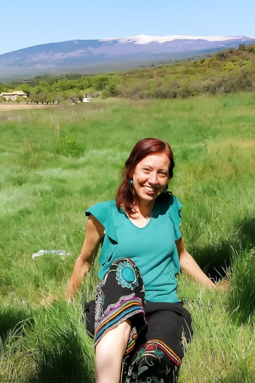 Woman smiling in green field with snow-capped mountain, Le Bacalan guest at Mormoiron, France