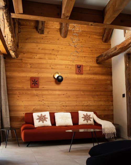 Modern rustic seating area at Chalet Névalia with red sofa, wooden beams, and festive décor in Ceillac