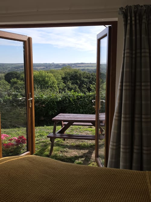 Valley View room at Ailwood Farm Stay with open doors overlooking rolling Dorset countryside and picnic table