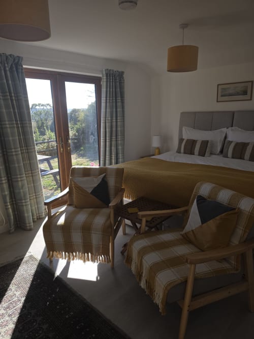Valley View bedroom at Ailwood Farm Stay, Dorset with king bed, seating area, and countryside views through patio doors