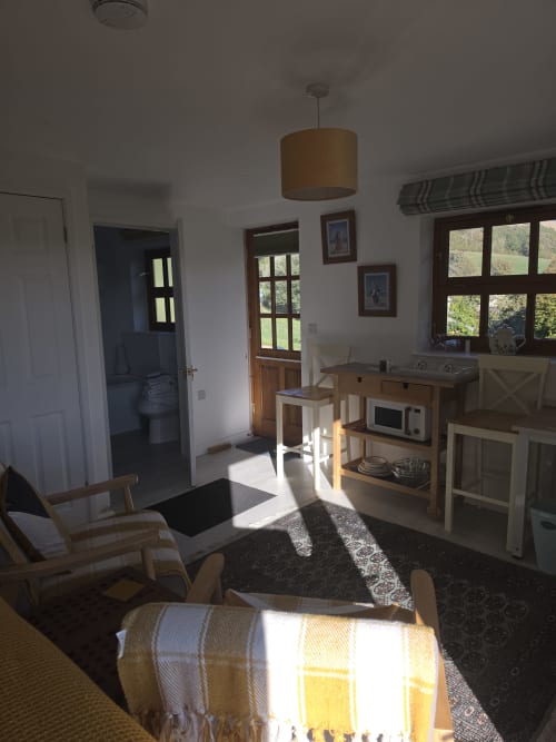 Bright open-plan kitchen and living area at Ailwood Farm Stay, Dorset, with wooden furniture and countryside views through
