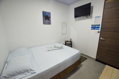 Habitación temática de estrellas de mar en Vamos pa San Andrés Isla con cama blanca, TV y vista al jardín en San Andrés, Colombia