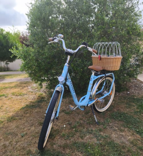 Vélo vintage bleu clair avec panier en osier garé au jardin Le Clos d'Émilie à Saint-Marcel, France