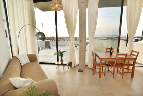 Apartamento Sunset House en El Cotillo con vistas al mar, salón abierto con sofá beige, mesa de comedor y