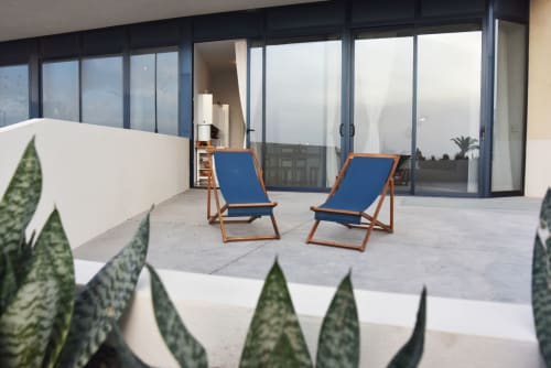 Terraza moderna en Sunset House, El Cotillo con tumbonas azules, plantas en macetas y vistas al mar