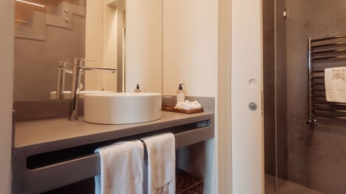 Baño moderno en villa Quinta Das Pirâmides con lavabo circular blanco, grifería cromada, toallero climatizado y vistas a la montaña