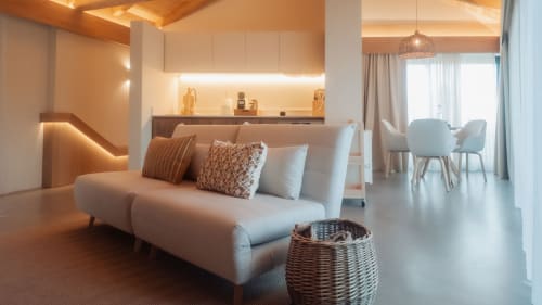 Sala de estar moderna en Quinta Das Pirâmides con sofá curvo, iluminación ambiental, cocineta y vistas a las montañas