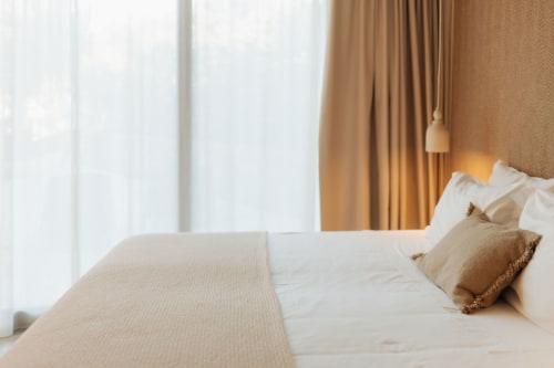 Dormitorio luminoso en villa Quinta Das Pirâmides con sábanas blancas, almohadas beige, vistas montañosas y ambiente acogedor