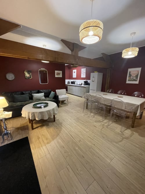 Cottage spacieux à privatiser au Clos d'Émilie : murs bordeaux, salle à manger, canapé noir, plafond tressé moderne