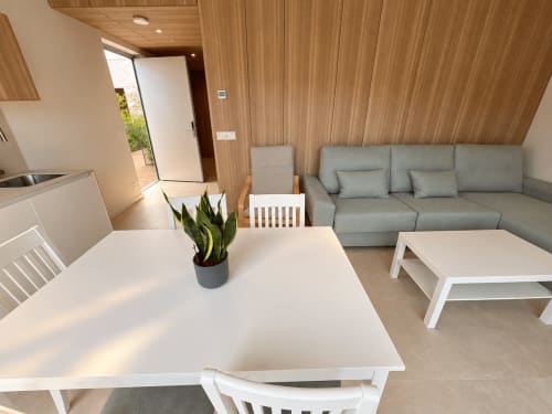 Luminoso apartamento Holibai en Baiona con zona de comedor, sofá gris, techo de madera y acceso a terraza