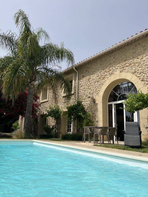 Luxueux gîte à Capestang avec bâtisse en pierre, piscine, palmier et entrée voûtée