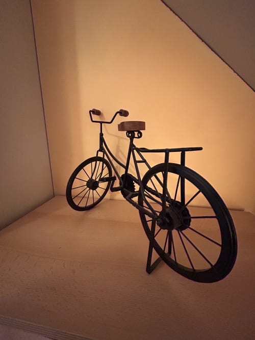 Sculpture de vélo en métal noir avec porte-bagages dans l'appartement Le Duplex 1 d'Hébergement Luxeuil Les Bains