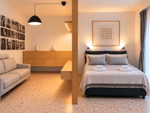 Monolocale moderno Easystay Bari con letto, divano, cassettone in legno e illuminazione calda