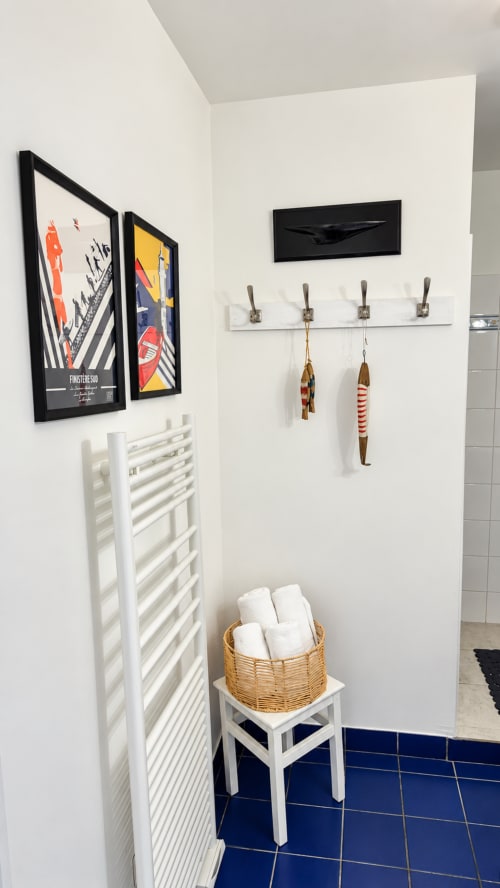 Détail de la salle de bain de la chambre Heol à Ty Coz Breizh, Guidel, avec linge de toilette, sèche-serviettes et décoration marine.