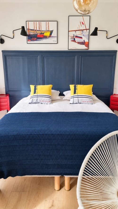 Chambre à thème nautique à Ty Coz Breizh avec tête de lit bleue, oreillers jaunes et décoration voilier à Guidel.