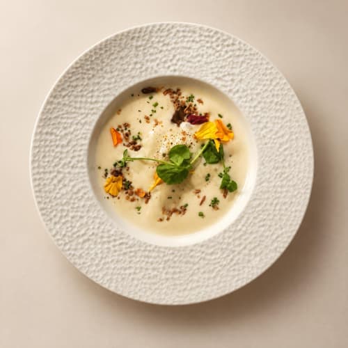 Creamy soup with edible flowers and herbs at Ô Château, Hayange