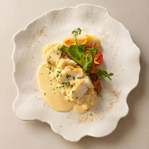 Elegant plated fish dish with risotto and vegetables at Ô Château restaurant in Hayange