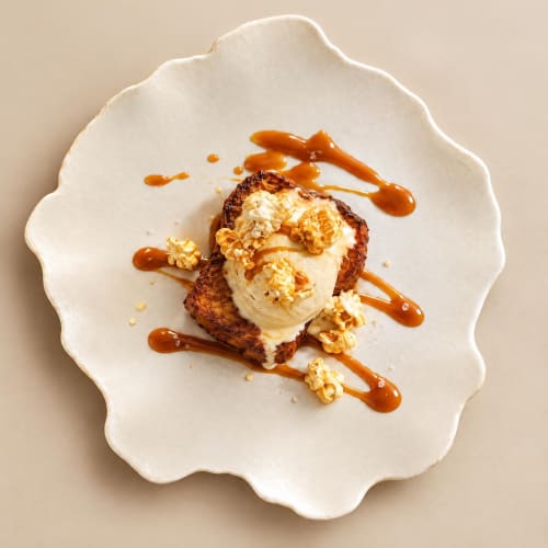 Gourmet dessert at Ô Château Hayange: toasted bread with vanilla ice cream, caramel drizzle and crispy garnish