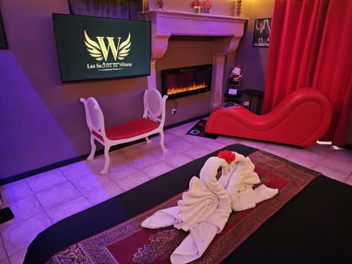 Chambre romantique aux Secrets de Winna avec cheminée, canapé rouge vague et cygnes en serviettes