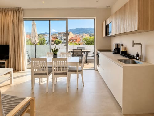 Cocina y comedor modernos de apartamento con vistas a la ciudad de Baiona, España en el hotel Holibai
