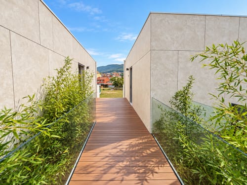 Pasarela de madera moderna con bambú que conduce al apartamento Holibai en Baiona con vistas a la ciudad