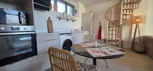 Cocina y comedor moderno con vistas al lago en NN Patrimoine, Douvaine, con electrodomésticos y escalera de caracol