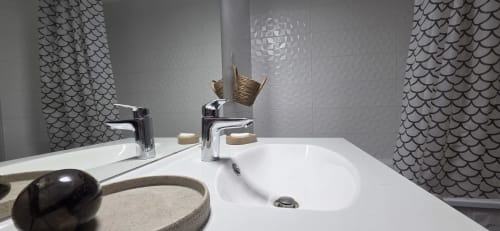 Baño moderno del apartamento La Perle du Léman en NN Patrimoine, Douvaine, con doble lavabo, grifería cromada y detalles estampados