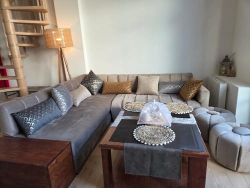 Sala de estar moderna en apartamento La Perle du Léman de NN Patrimoine, Douvaine con sofá gris, mesa de madera