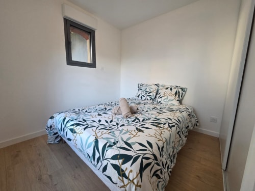 Dormitorio moderno en NN Patrimoine en Douvaine con ropa de cama estampada, pisos de madera y ventana pequeña