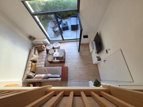 Salón moderno con claraboya, sofá beige, suelo de madera, terraza con vista al lago y televisor en NN Patrimoine