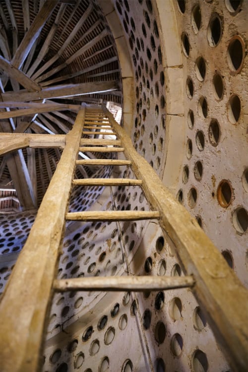 Escalier en bois montant à travers la tour en pierre historique du Château de Ribourdin, Chevannes
