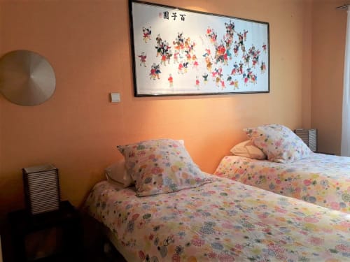 Chambre Suite Shanghai à la Royal Palmeraie avec lits jumeaux, literie florale, mur d'accent orange et œuvres d'art asiatiques encadrées