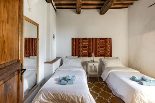 Camera doppia nella stanza Appaloosa dell'hotel Quarantallina a Buonconvento, con letti bianchi e travi in legno rustico