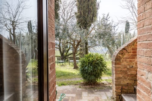 Vista dall'appartamento Appaloosa dell'hotel Quarantallina a Buonconvento, con giardino, cipressi e zona relax