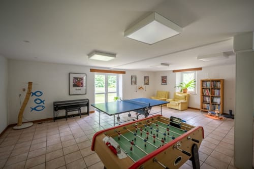 Salle de loisirs avec baby-foot et table de ping-pong au gîte Domaine Des Escouanes à Prudhomat