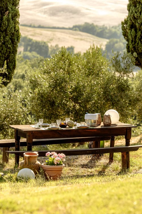 Tavolo in legno nella campagna toscana con ulivi e paesaggio di vigneti dell'hotel Quarantallina