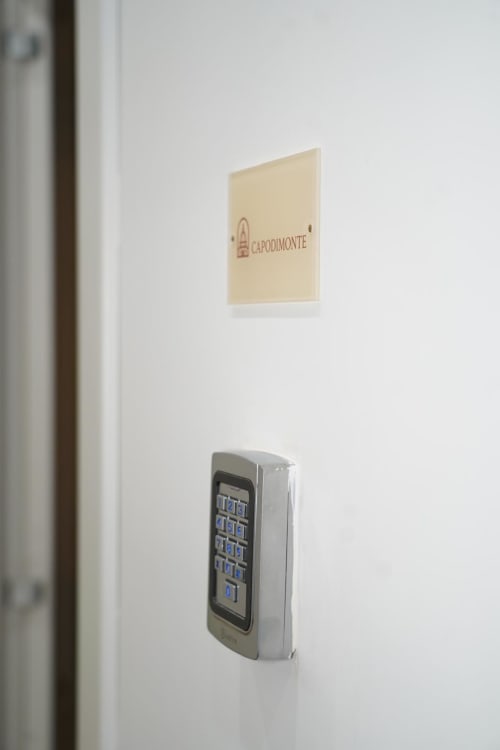 Tastiera e cartello della porta della suite Capodimonte dell'hotel Domusè a Napoli, Italia