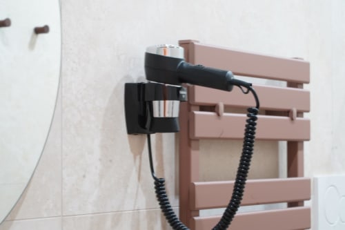 Supporto per asciugacapelli a parete nella camera San Gennaro dell'hotel Domusè, Napoli