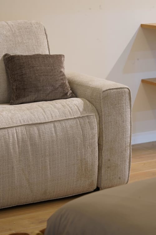 Poltrona rivestita in beige con cuscino nella suite San Gennaro dell'hotel Domusè a Napoli