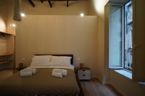 Camera San Gennaro dell'hotel Domusè a Napoli con letto moderno, lenzuola bianche e illuminazione ambientale