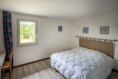 Chambre lumineuse à la Domaine Des Escouanes avec lit queen, vue sur le jardin et décoration épurée