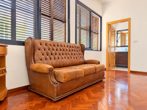Cognac leather chesterfield sofa in Casa do Moinho villa living room, Ribeira Brava, with wooden flooring and ocean views
