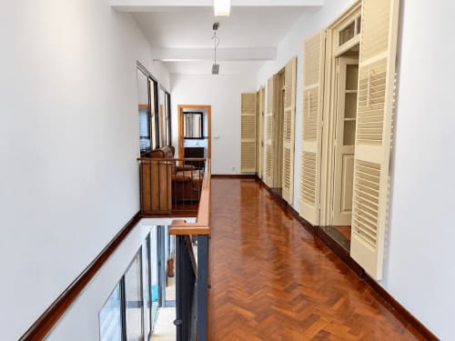 Bright hallway with wooden herringbone flooring, cream louvered doors, and metal railings at Casa do Moinho villa in Madeira
