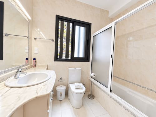 Modern bathroom in Casa do Moinho villa, Madeira with marble sink, toilet, shower enclosure and window