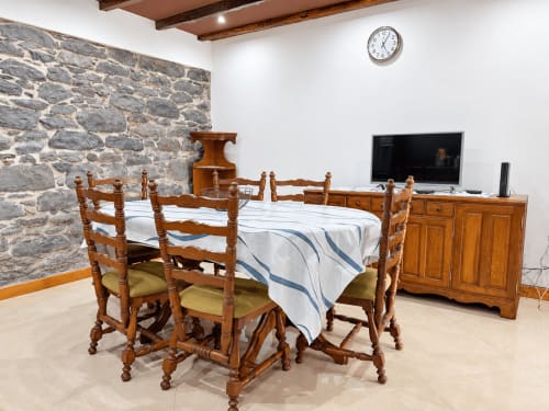 Wooden dining table with chairs and bed in Casa do Moinho villa at Check Madeira, Ribeira Brava