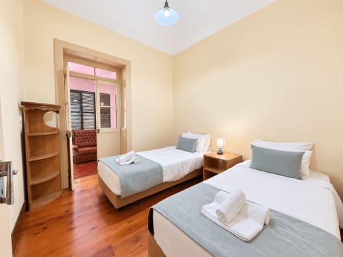 Twin beds with gray linens in Casa do Moinho villa bedroom, Ribeira Brava, Madeira