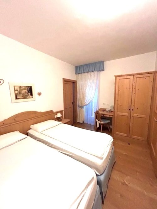 Genziana-Zimmer in der Residenza B&B Sissi in Almazzago mit Einzelbetten, Holzmöbeln und Balkon mit Stadtblick