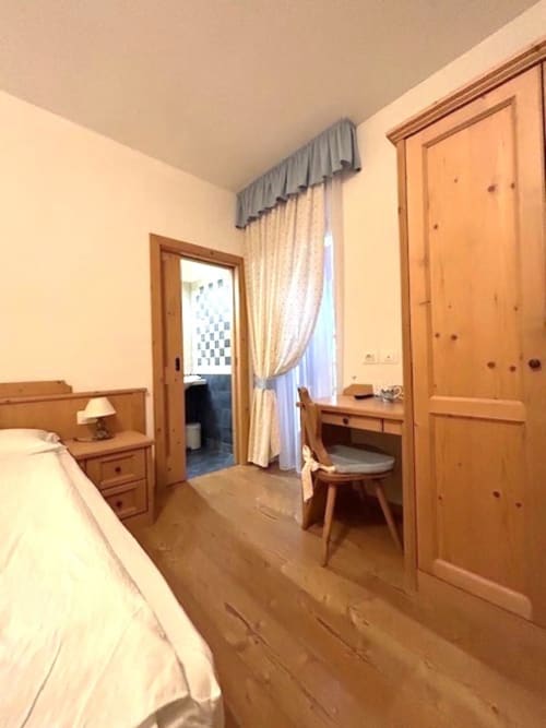 Genziana-Zimmer der Residenza B&B Sissi in Almazzago mit Holzmöbeln, Bett, Schreibtisch und Stadtblick