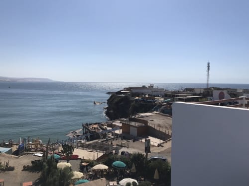 Imsouane beach resort with sea view terrace, parasols, and rocky coastline in Agadir, Morocco